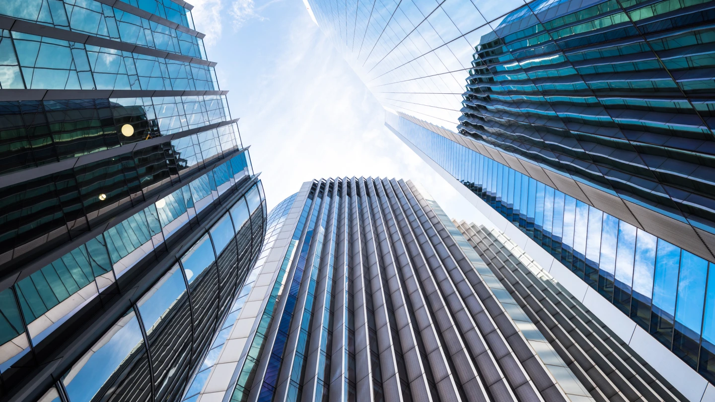 Low angle view of modern steel and glass skyscrapers with reflections, City of London, UK