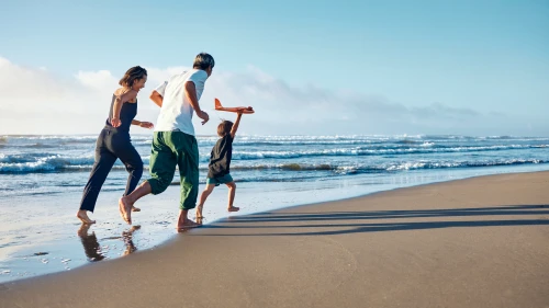 Back view of the family running along the coastline.