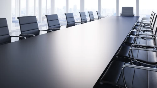 Large conference table with chairs in a meeting room in the high-rise office building, view to the skyline