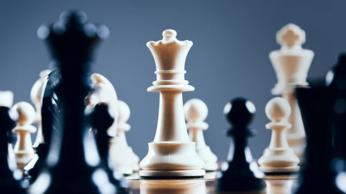 Close up of chessmen on chessboard, with the focus on the centrally placed white queen. Shot with Canon EOS 1Ds Mark III.