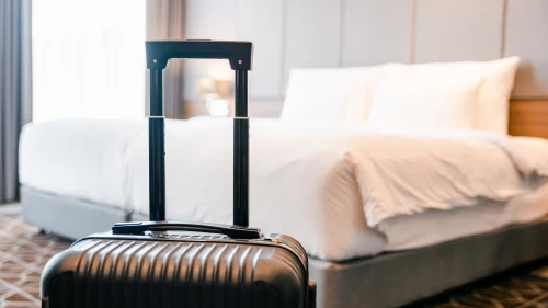 A suitcase placing in front of the bedroom in luxury hotel room